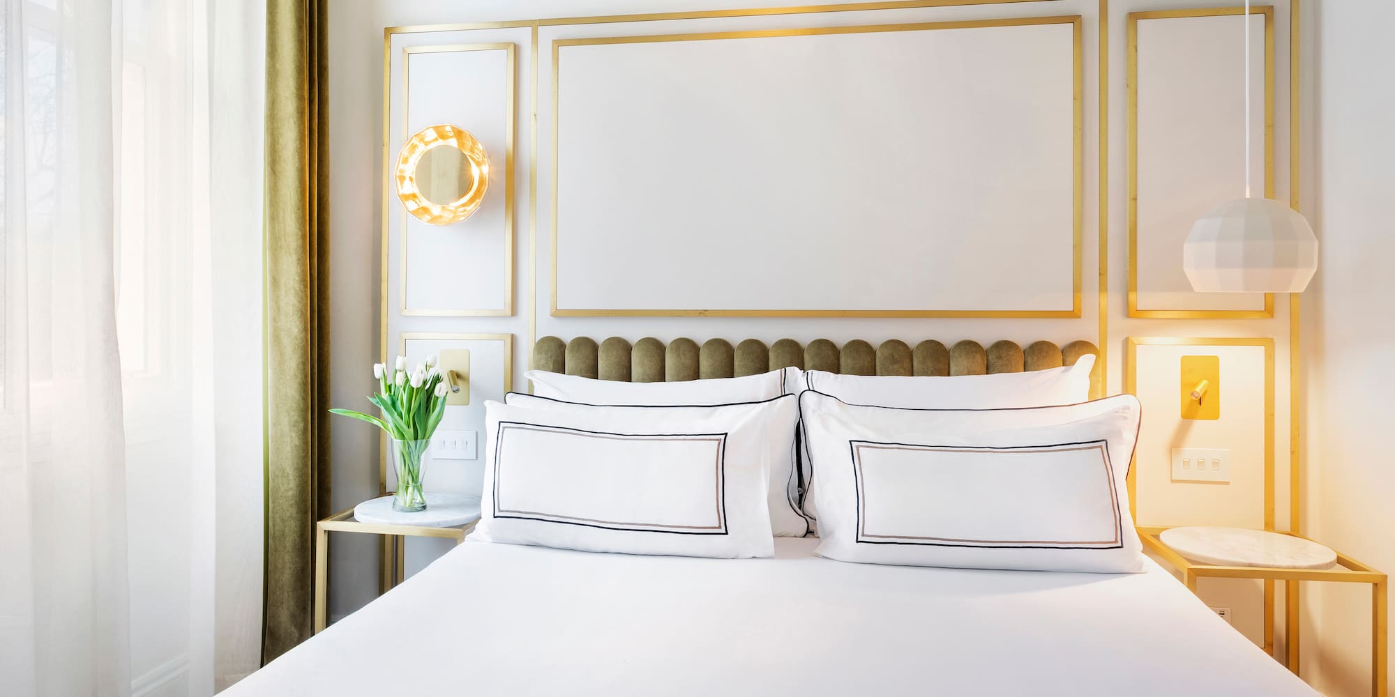 a bed with white sheets and pillows