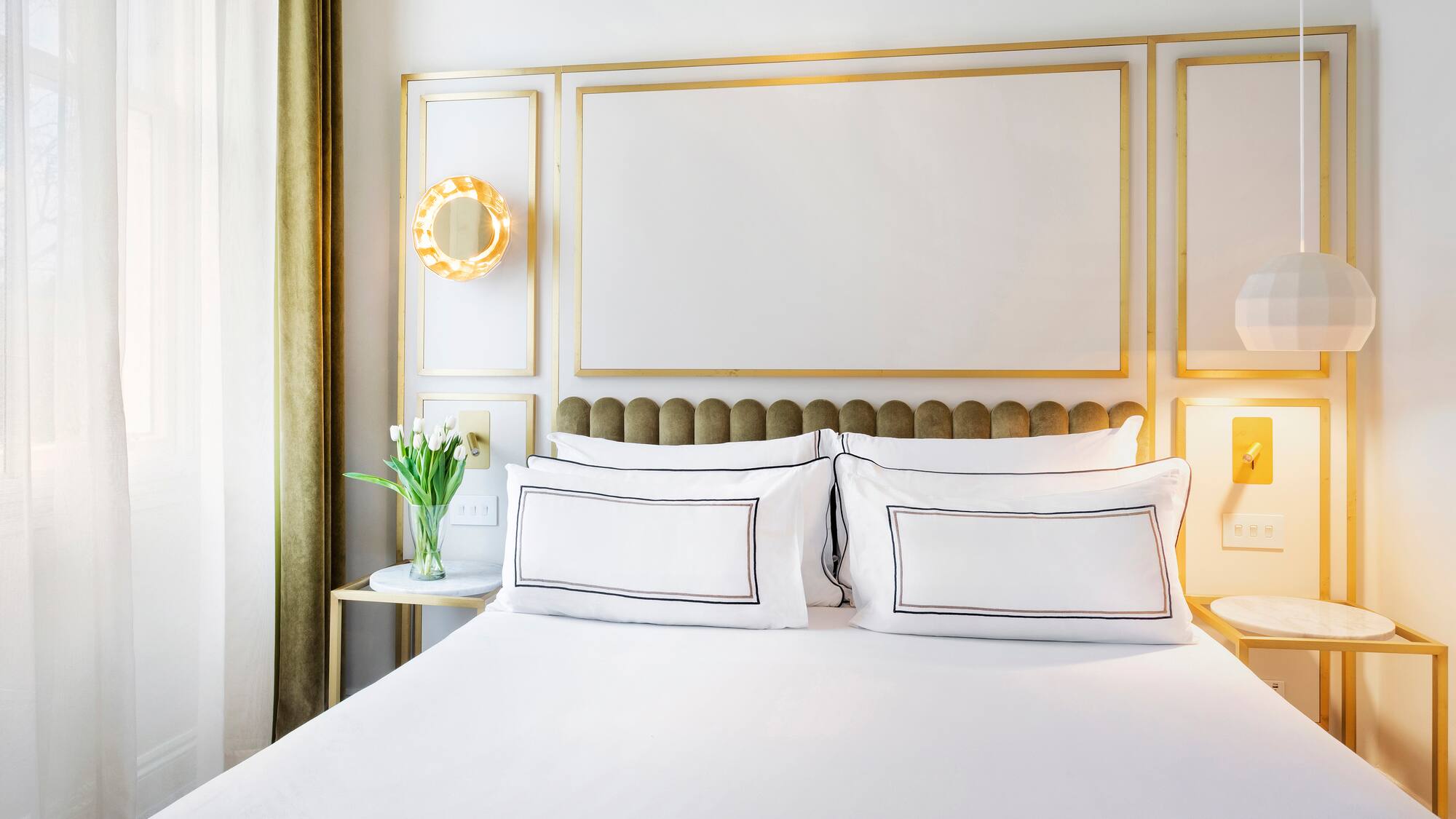a bed with white sheets and pillows