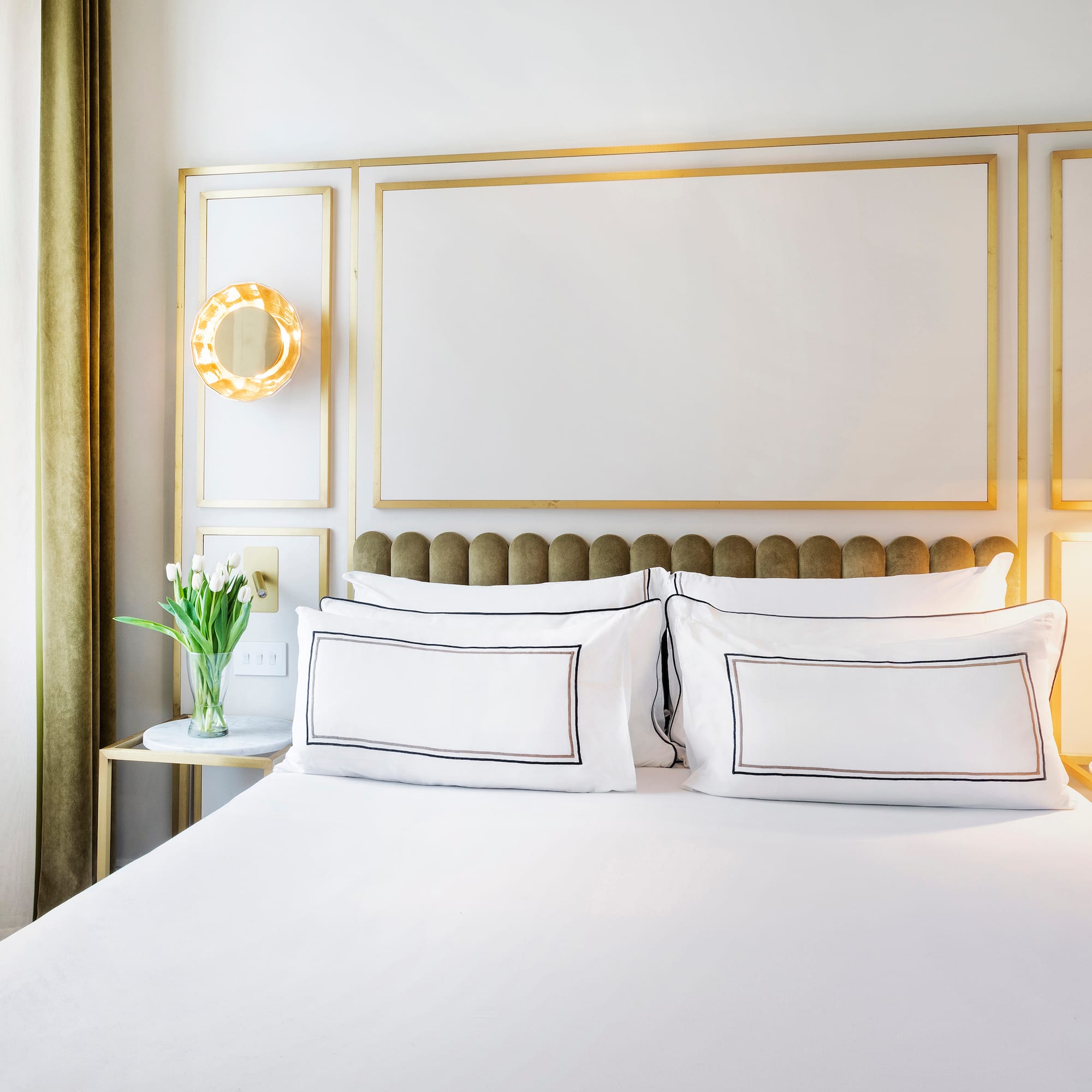 a bed with white sheets and pillows