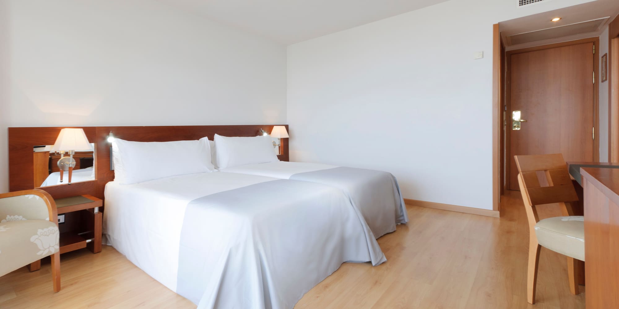 a room with two beds and a wood floor