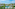 Tropical resort with a large swimming pool, modern buildings, and palm trees.