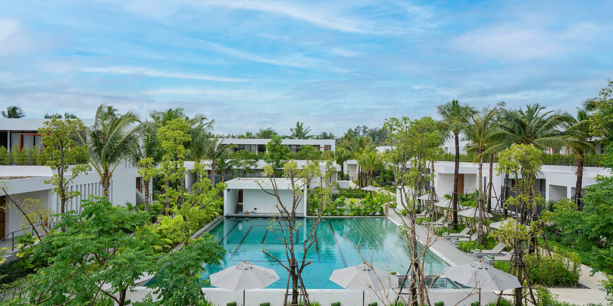 a pool surrounded by trees and buildings