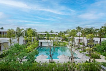 a pool surrounded by trees and buildings