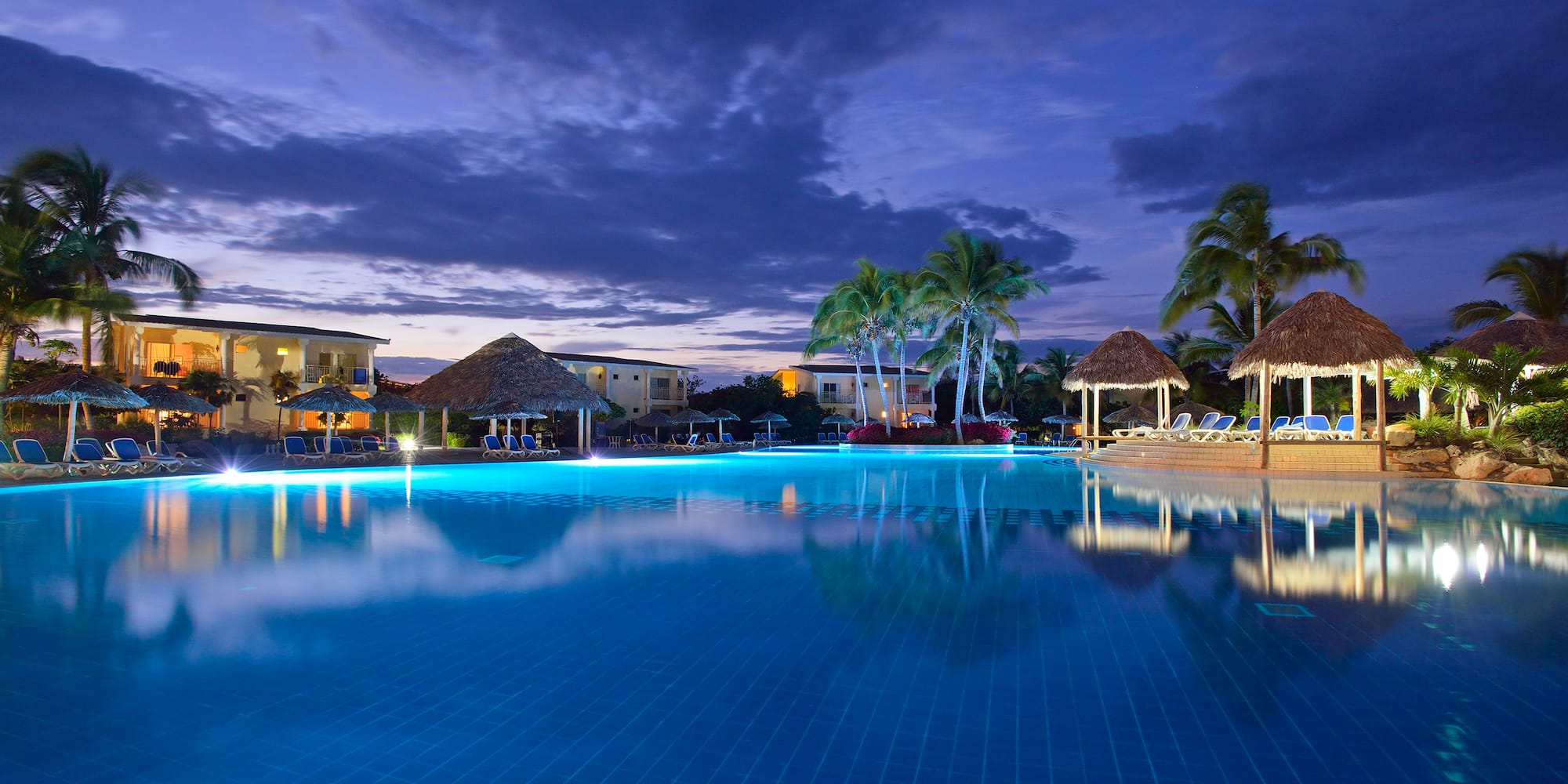 a pool with a building and palm trees