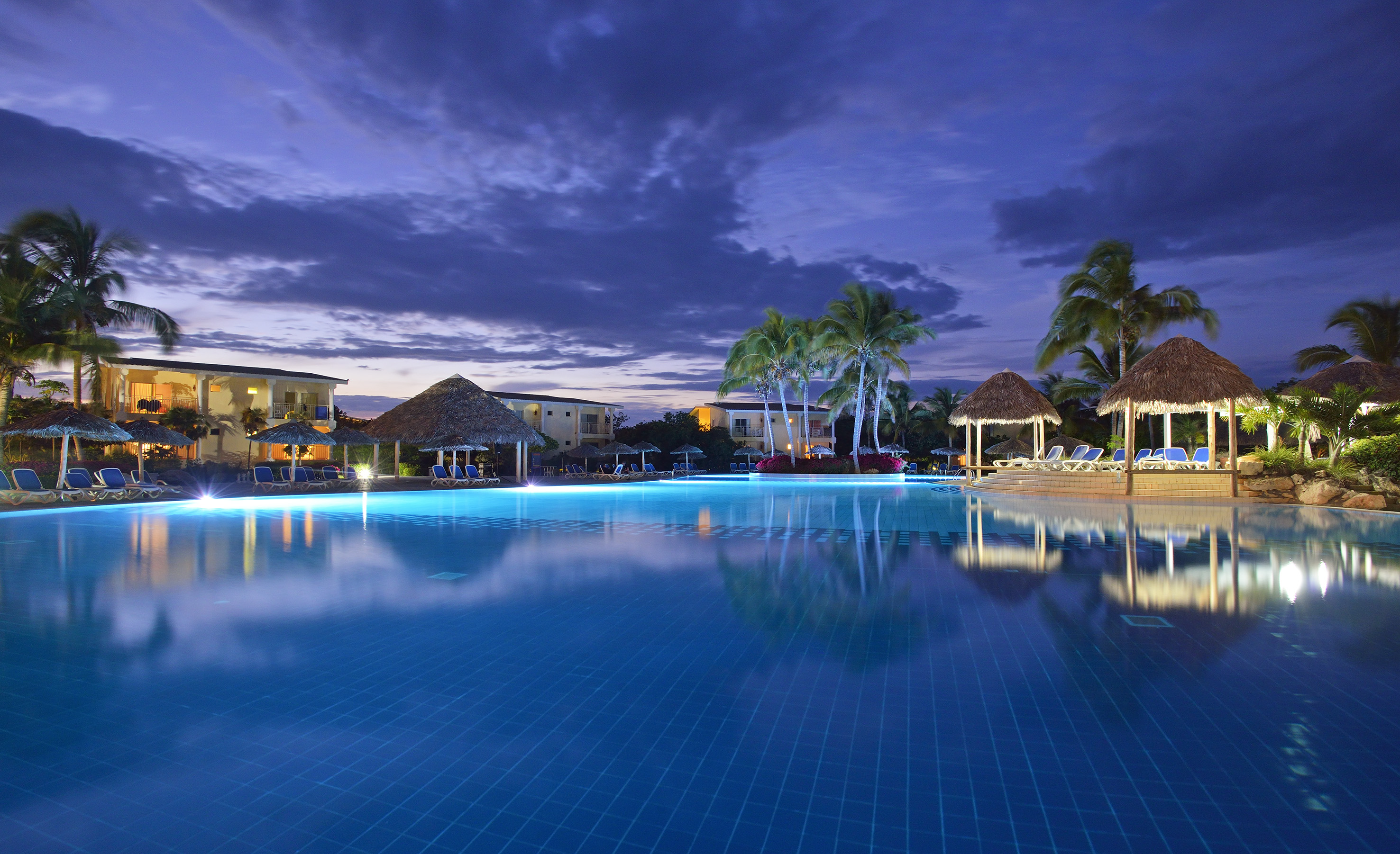 a pool with a building and palm trees
