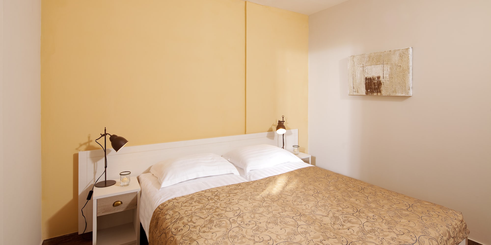 a bed with pillows and a lamp on the side