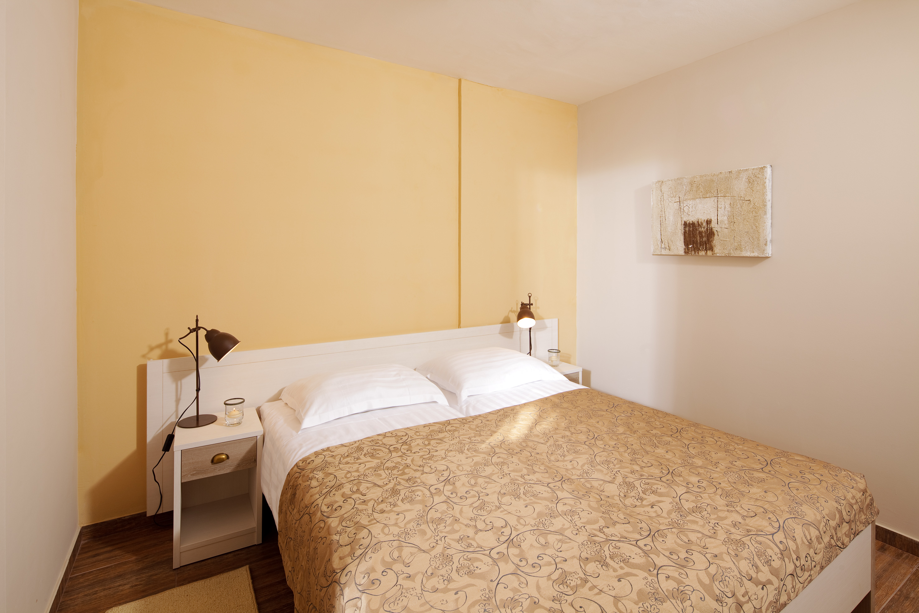 a bed with pillows and a lamp on the side