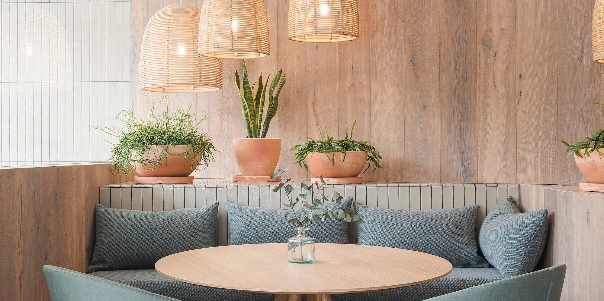 a table with chairs and a round table with a wood wall and a light fixture
