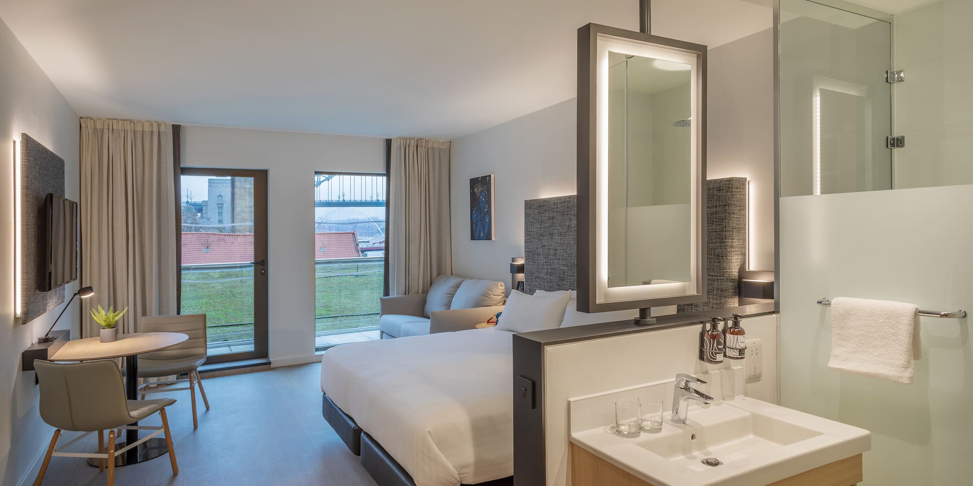 a room with a bed and sink and a mirror