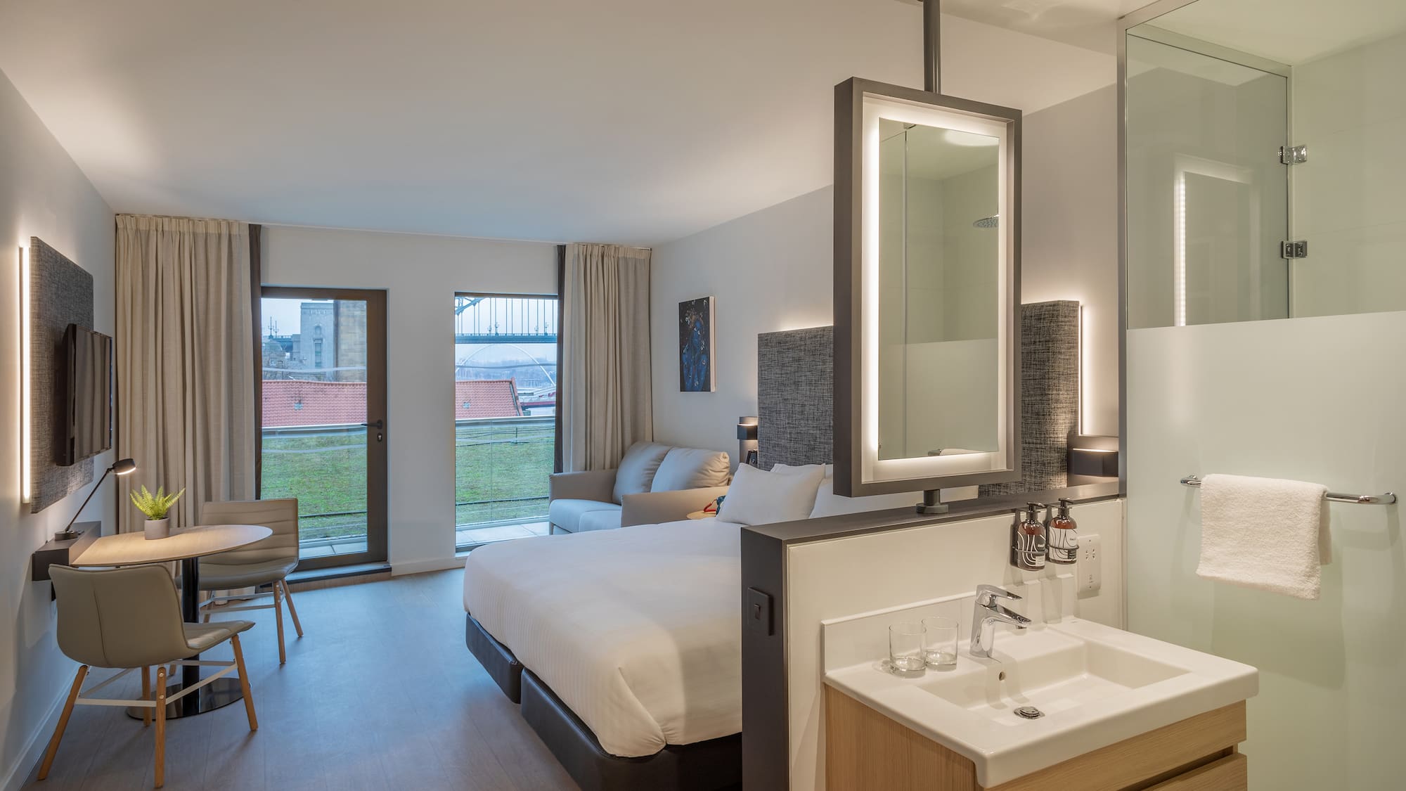 a room with a bed and sink and a mirror