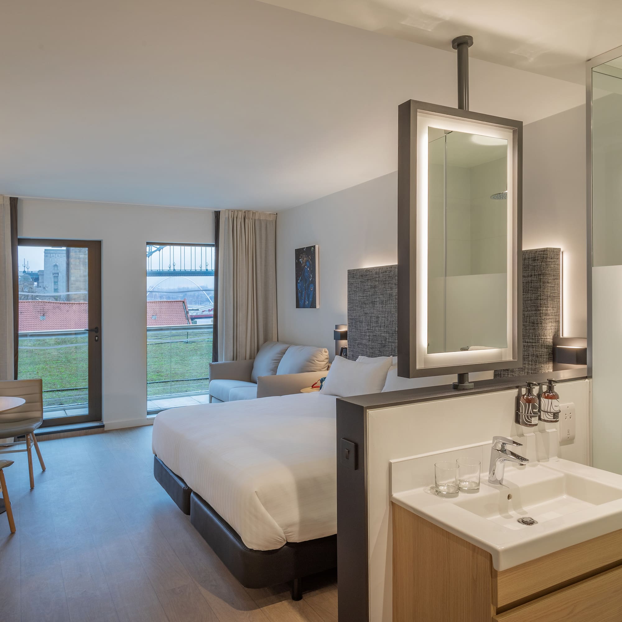 a room with a bed and sink and a mirror