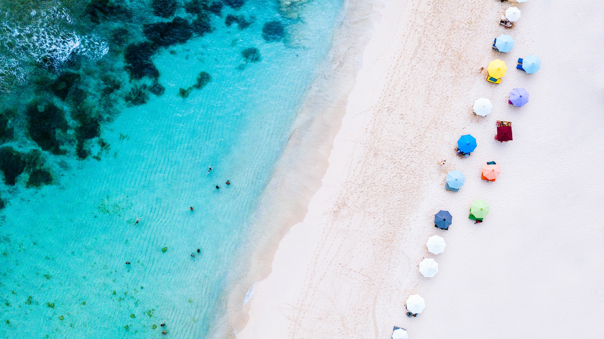 a beach with umbrellas and people on it
