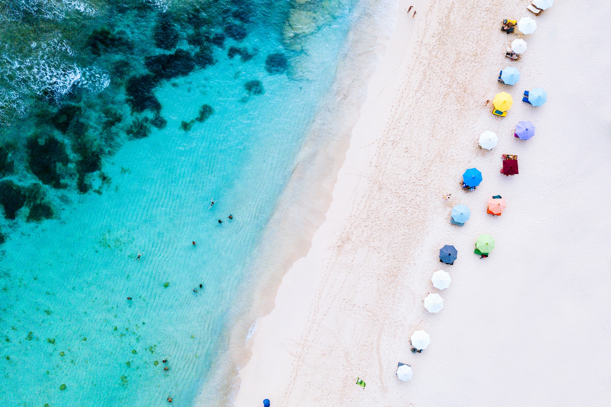a beach with umbrellas and people on it