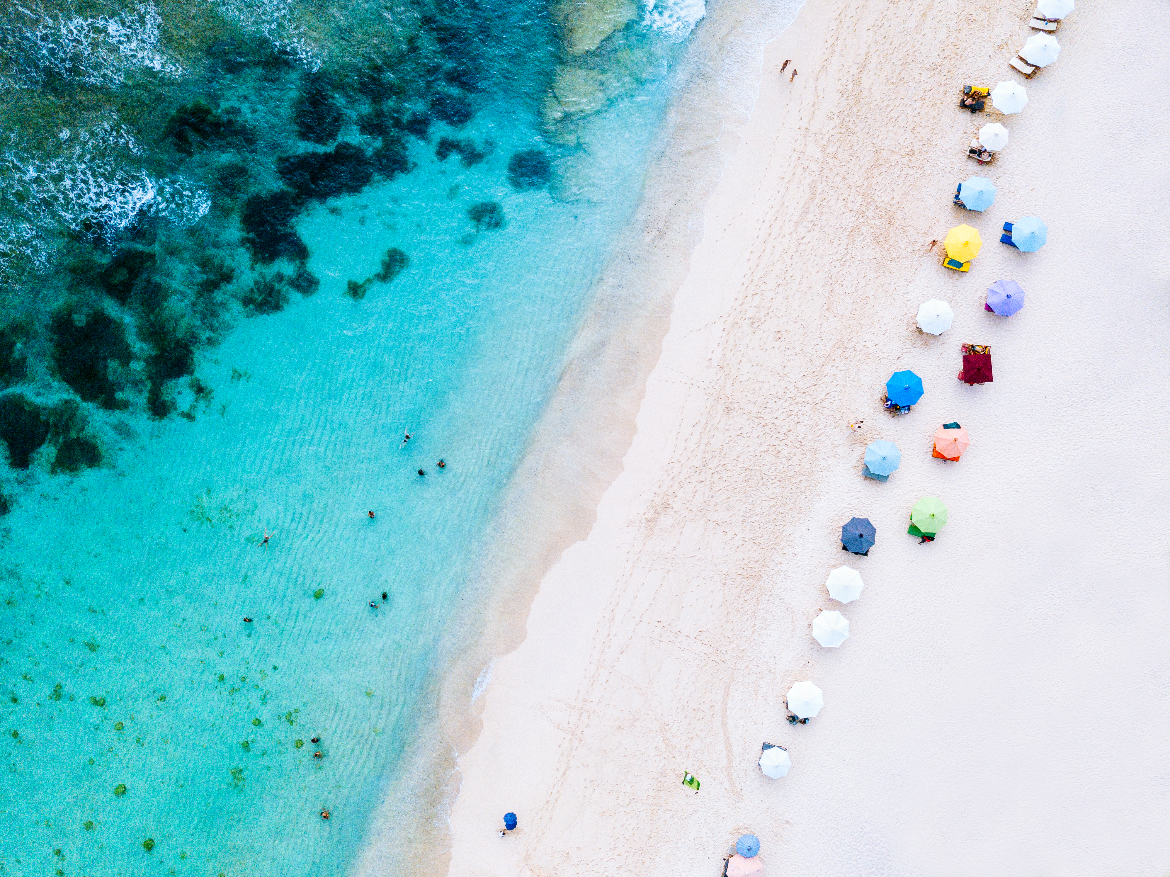 a beach with umbrellas and people on it
