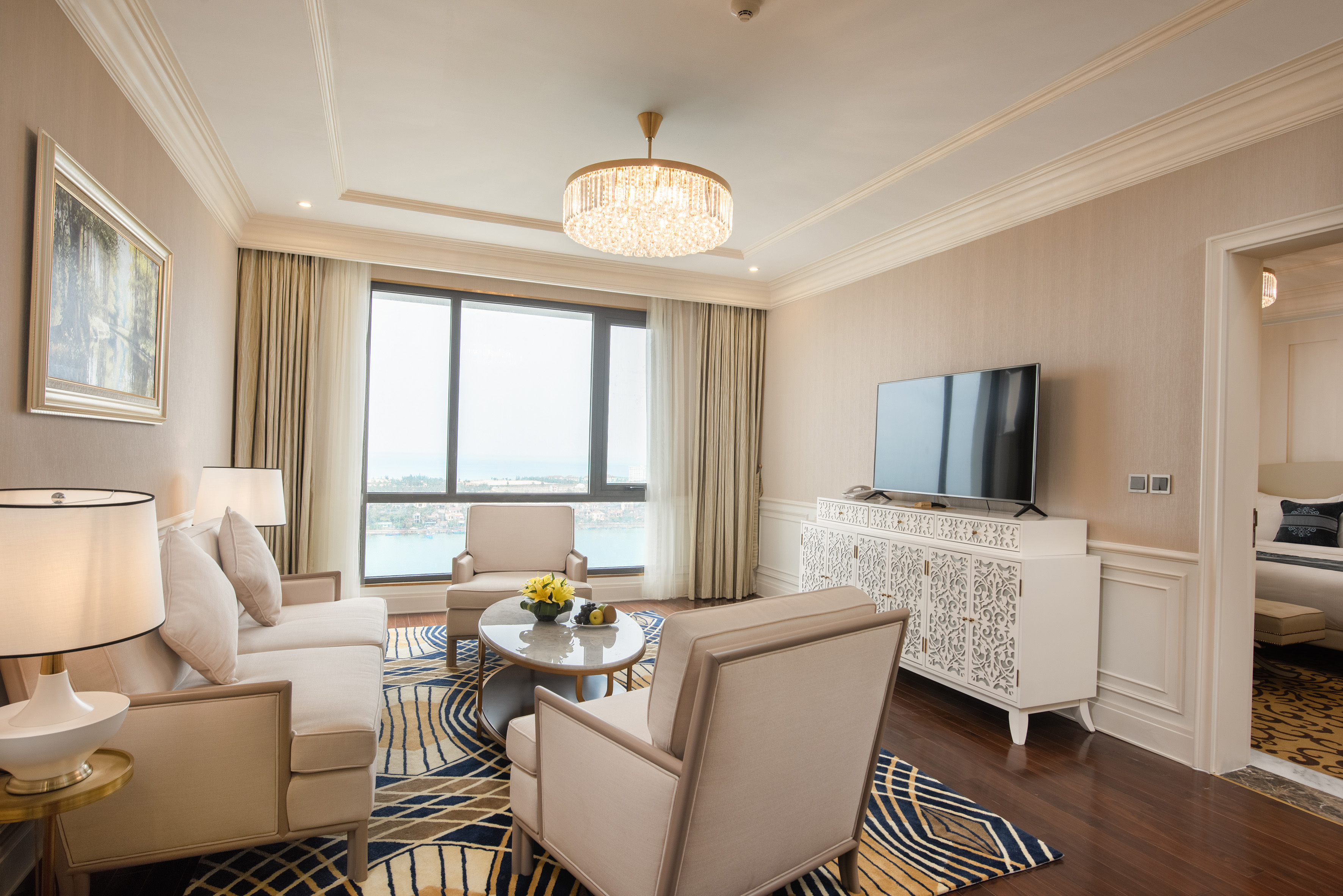 Luxury hotel living room with waterfront view and modern decor.