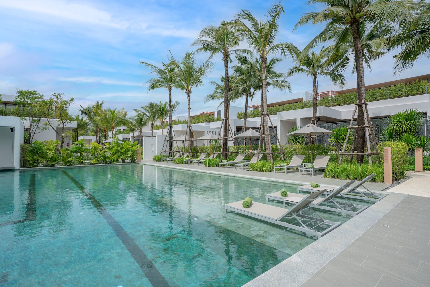a pool with lounge chairs and palm trees