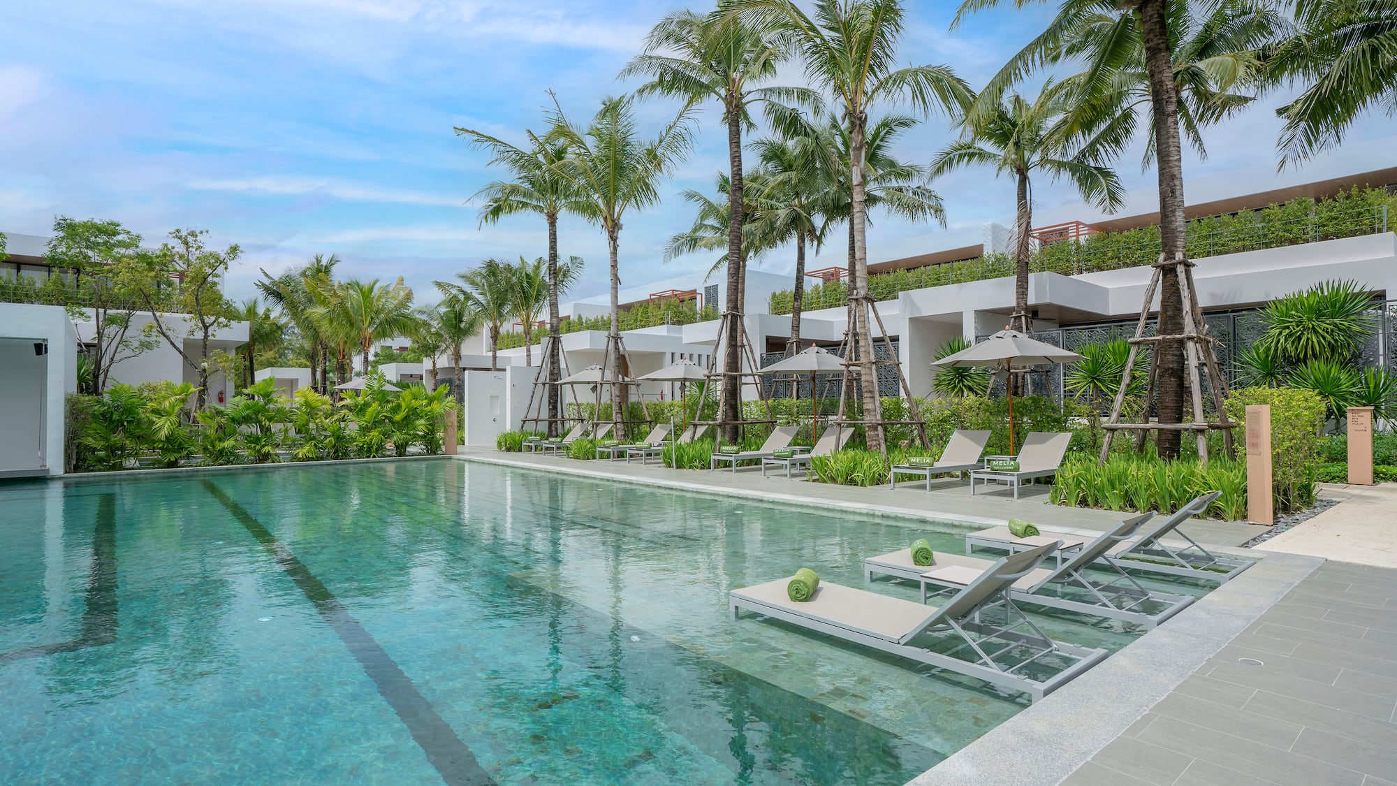 a pool with lounge chairs and palm trees