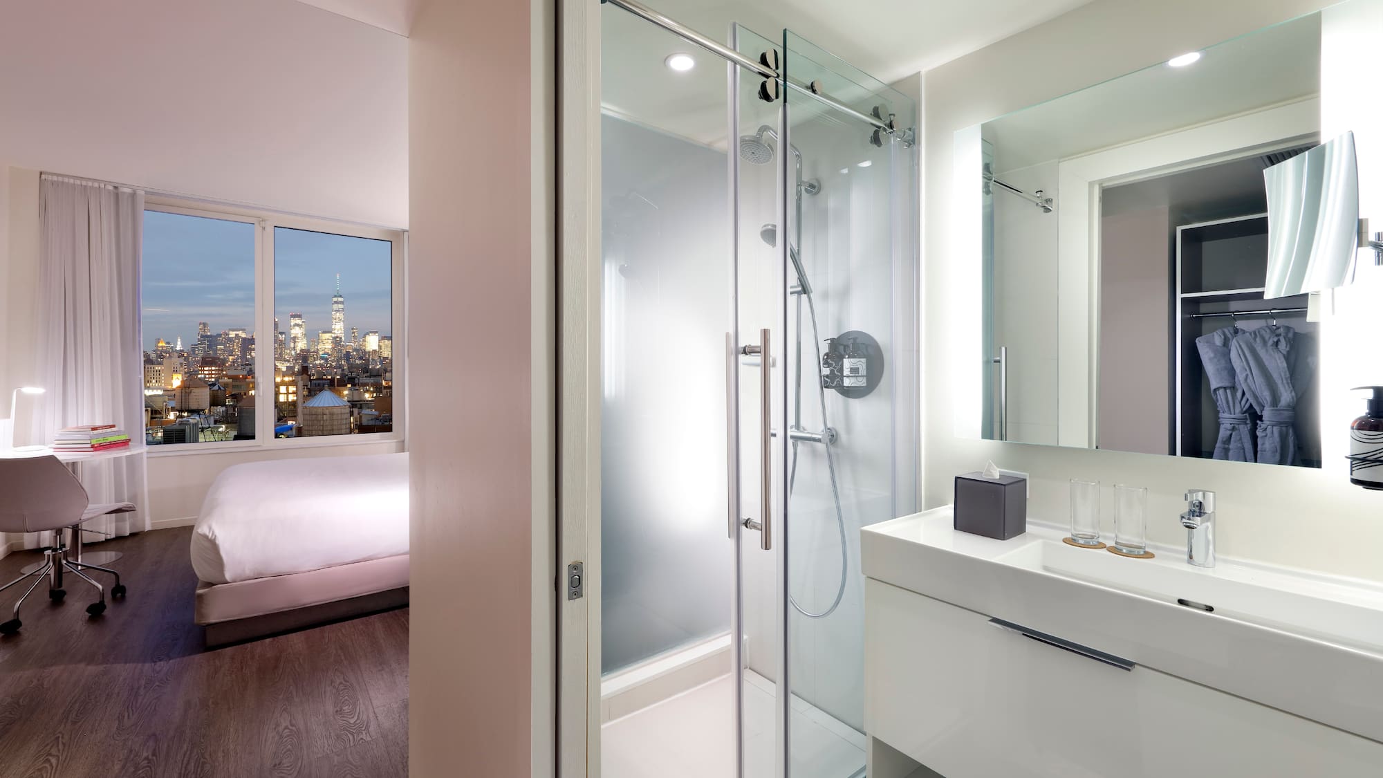 a bathroom with a glass shower and a bed