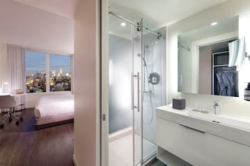 a bathroom with a glass shower and a bed