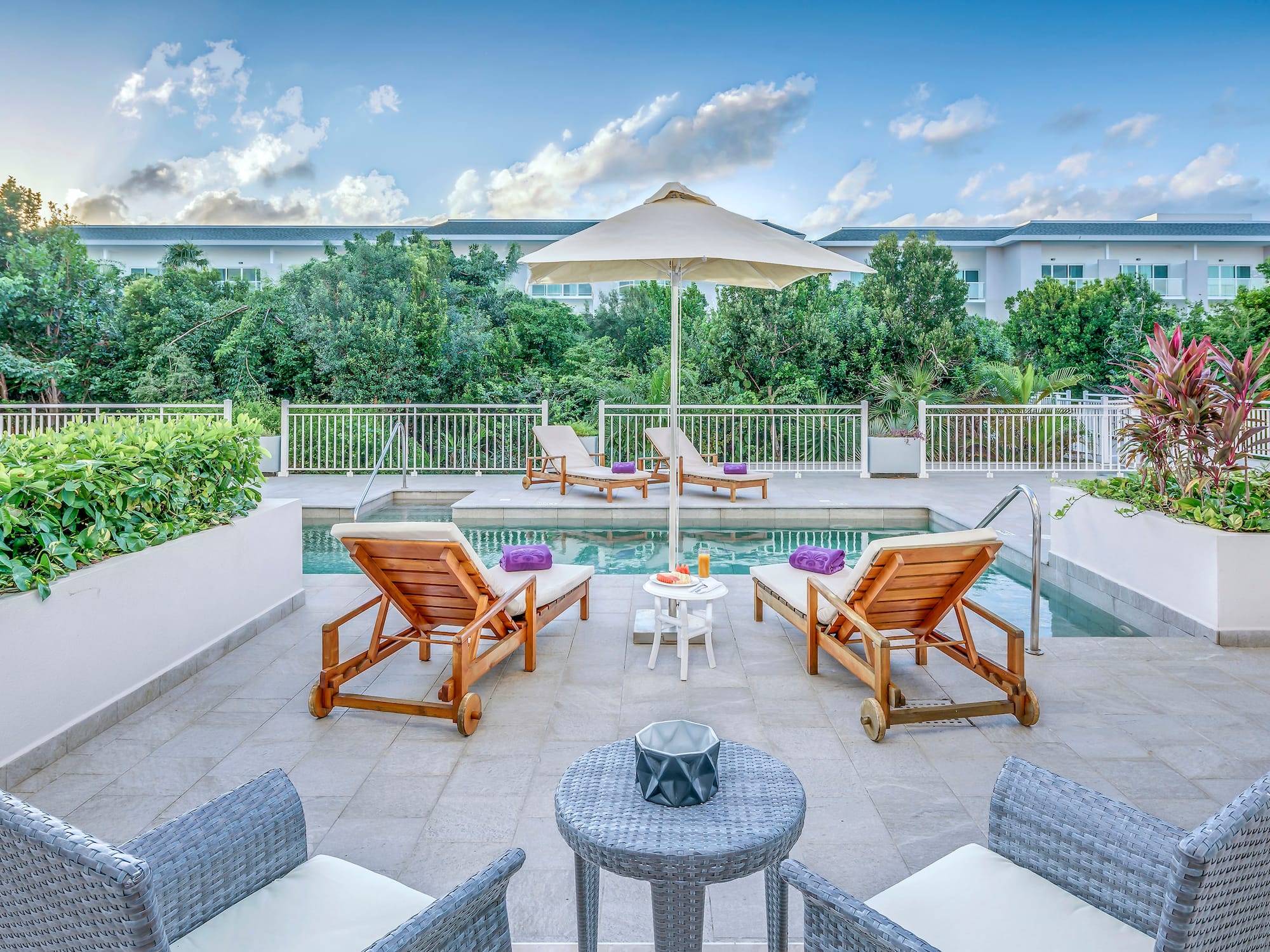 a man and woman sitting in chairs near a pool