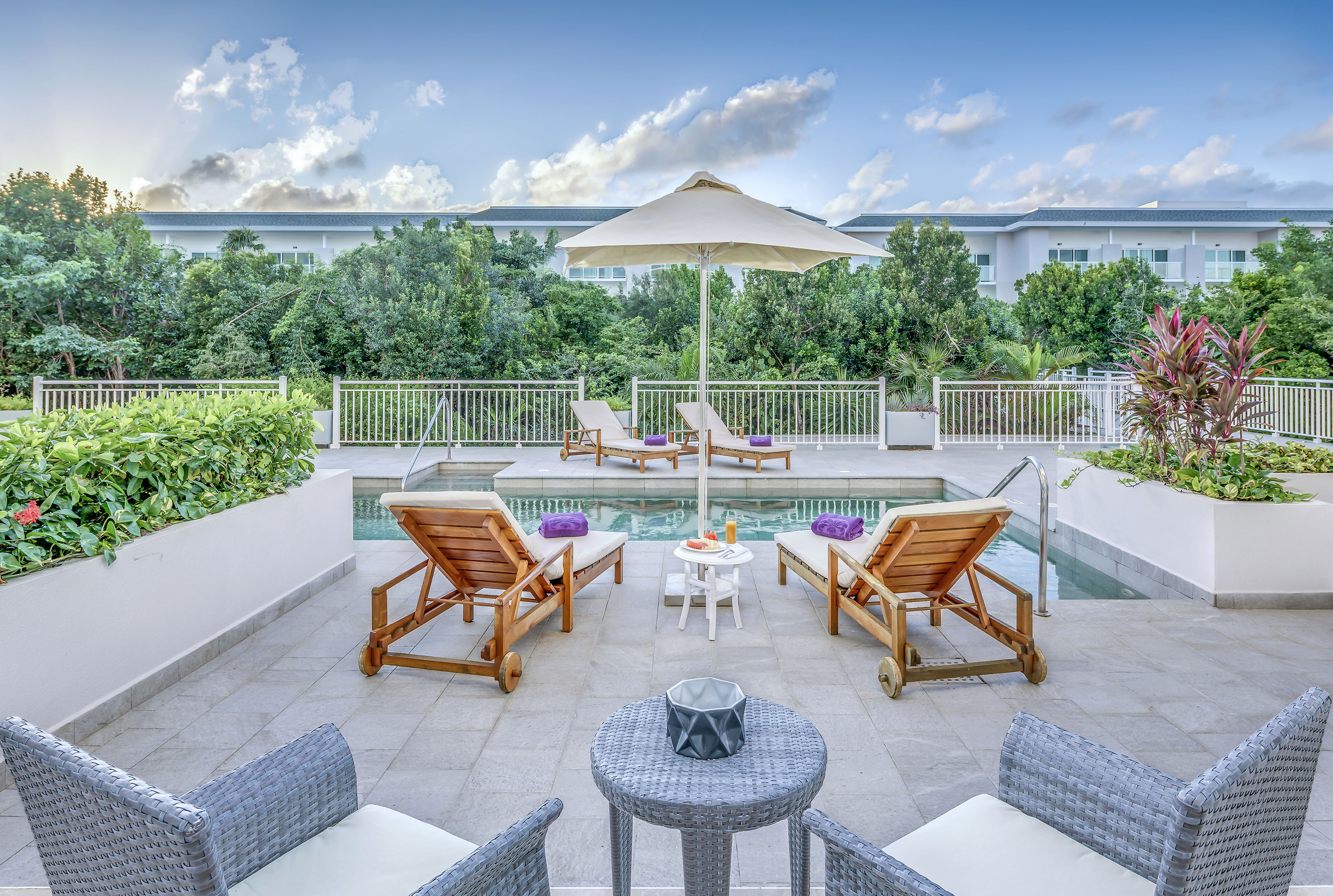 a man and woman sitting in chairs near a pool
