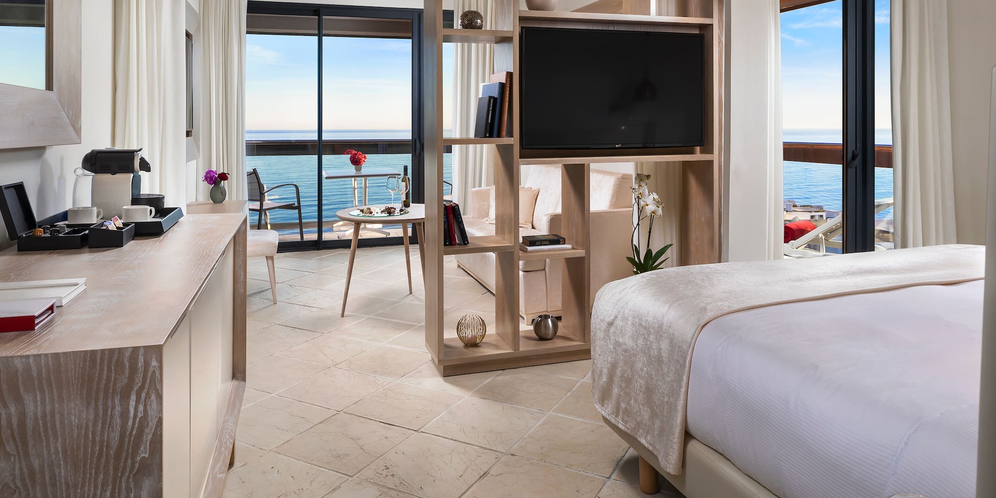 a room with a television and a view of the ocean