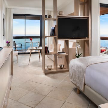 a room with a television and a view of the ocean