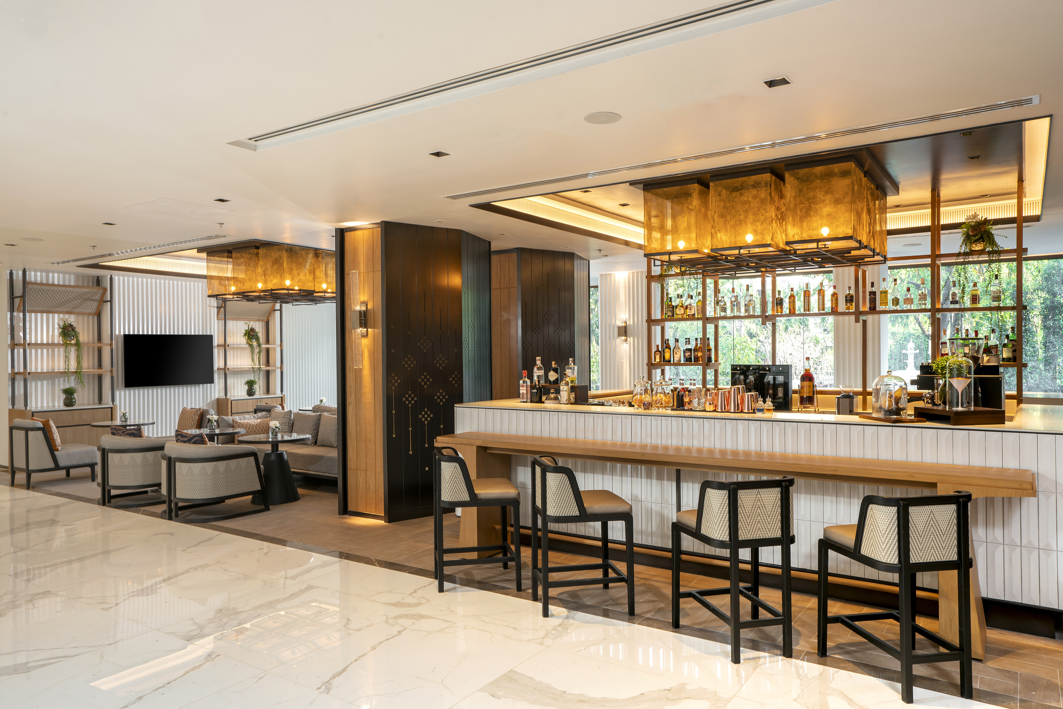 Modern hotel bar lounge with a stocked counter and comfortable seating.