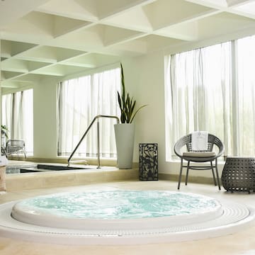 a hot tub in a room with a large tub and chairs