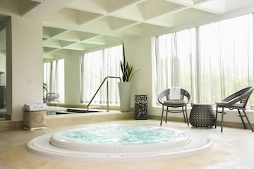 a hot tub in a room with a large tub and chairs