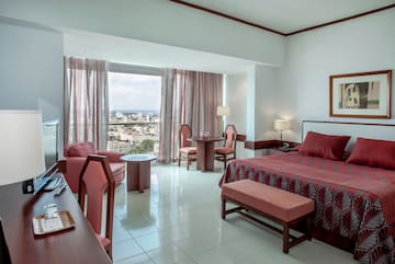 a room with a bed and chairs and a table