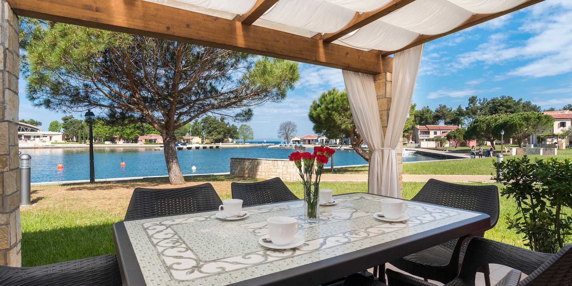 a table and chairs with a view of water and trees