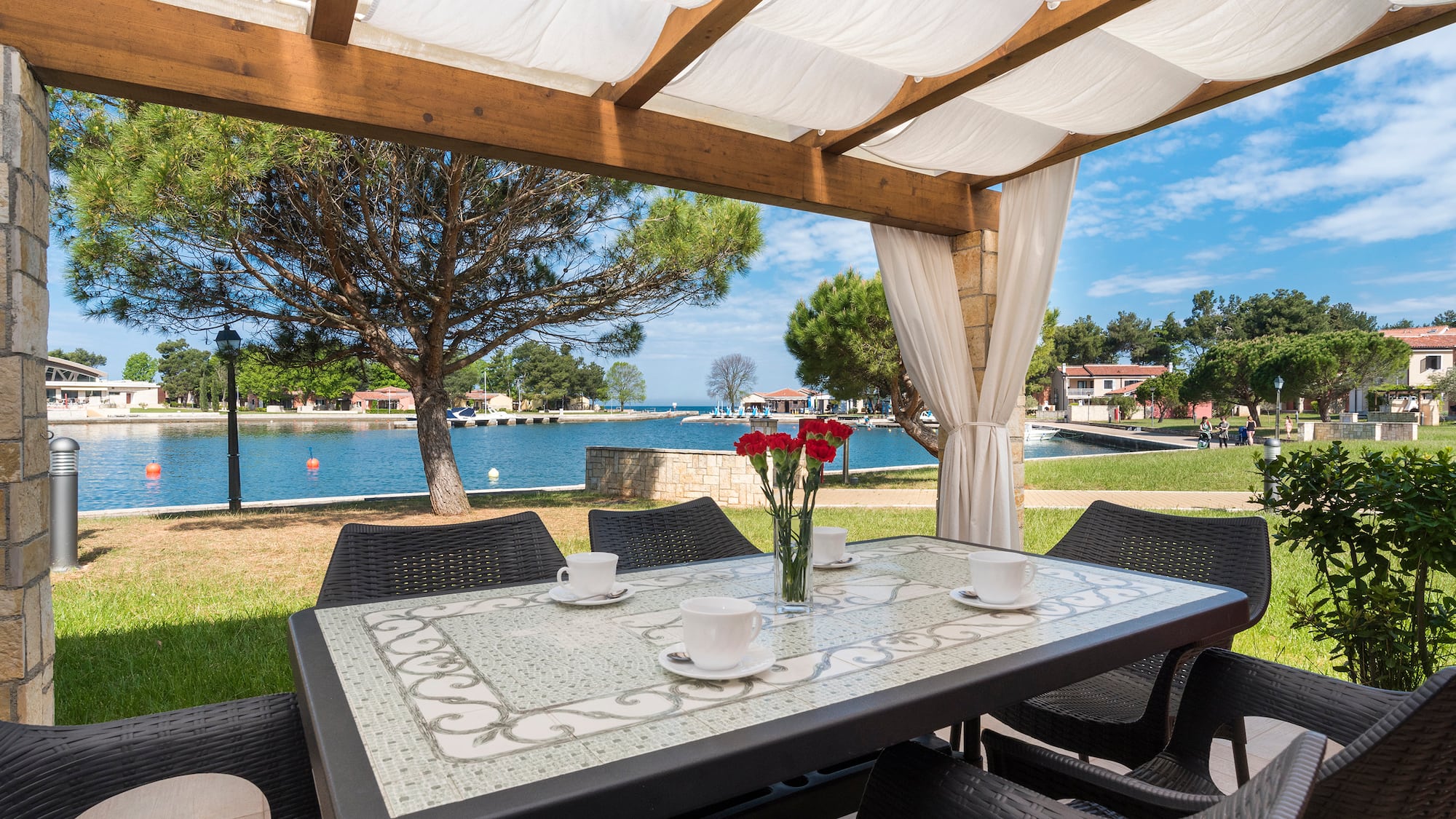 a table and chairs with a view of water and trees