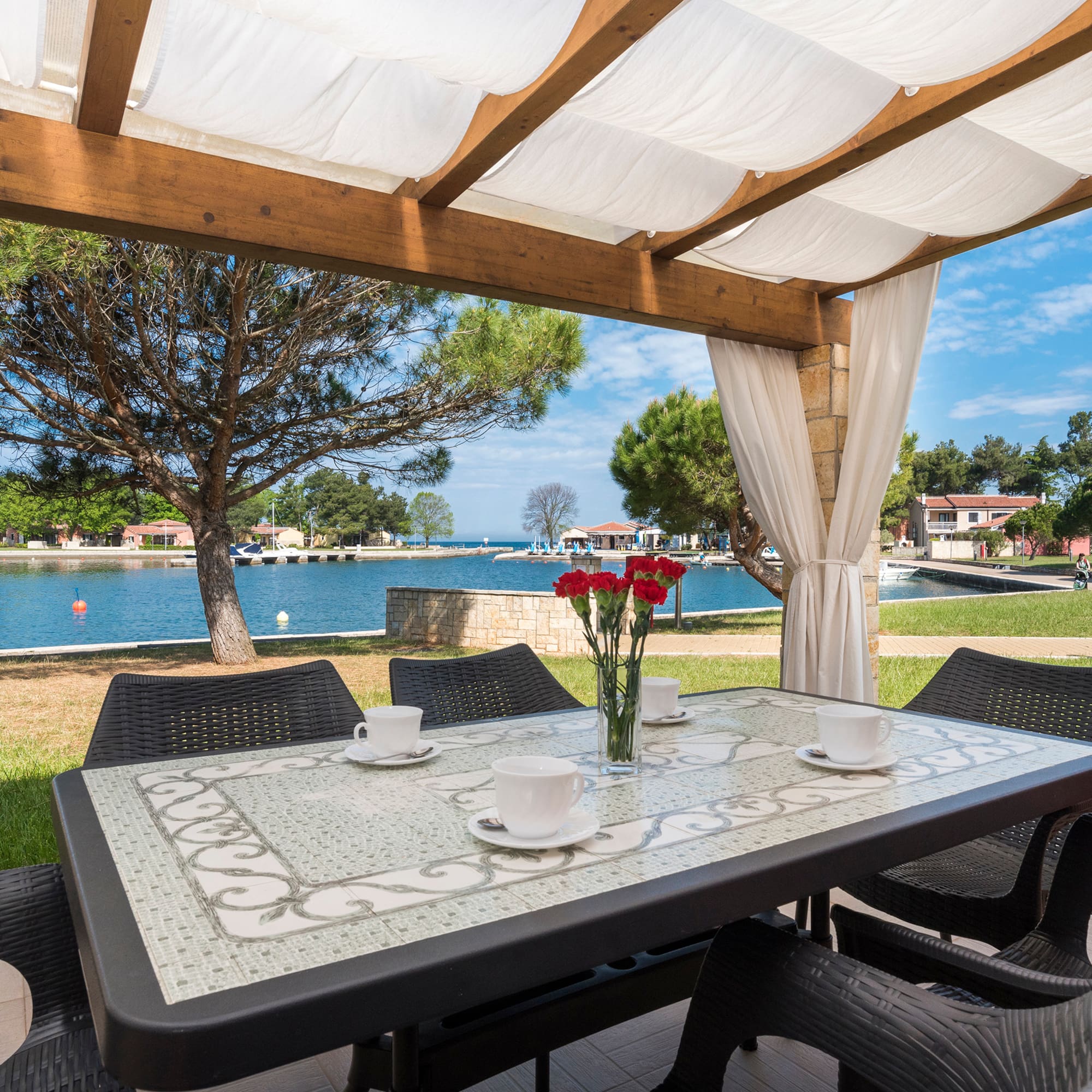a table and chairs with a view of water and trees