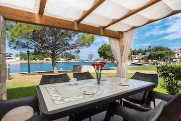 a table and chairs with a view of water and trees