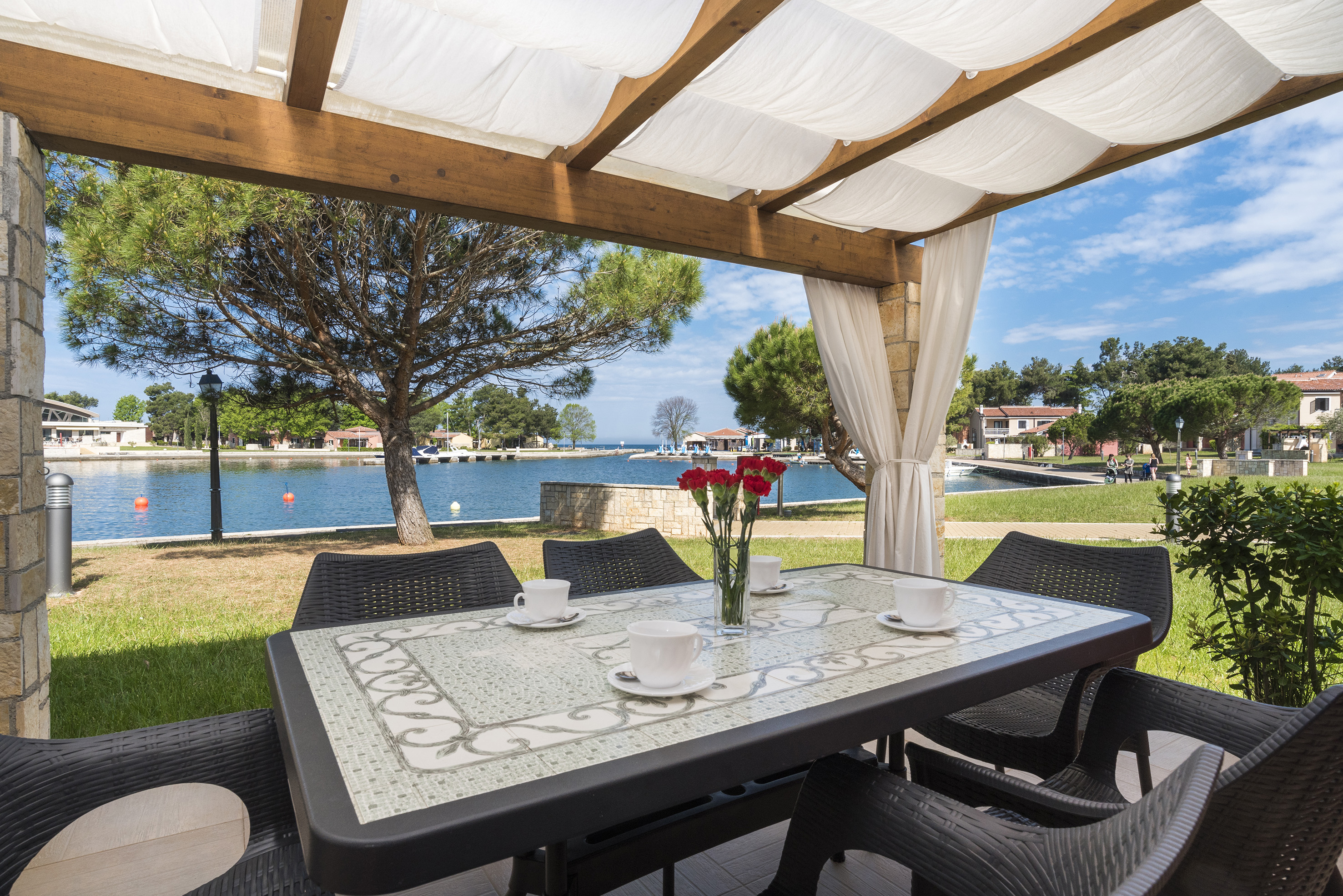 a table and chairs with a view of water and trees