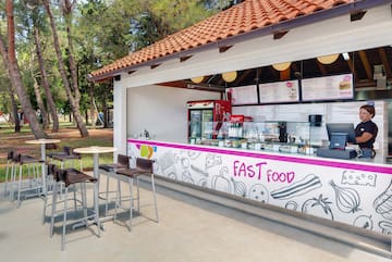 a fast food stand outside with tables and chairs