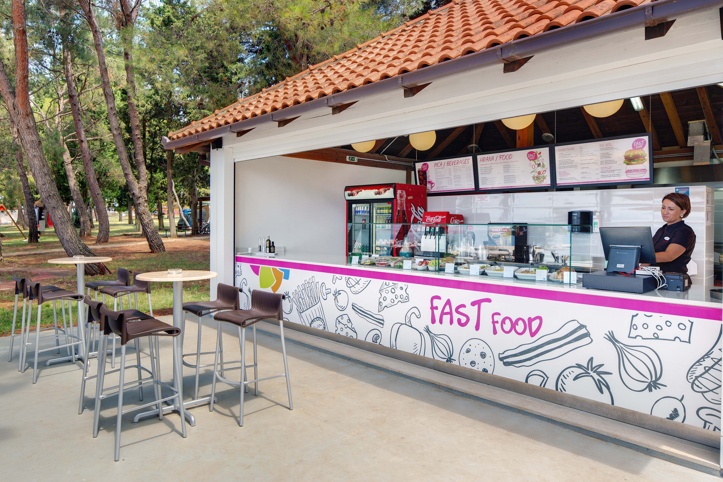 a fast food stand outside with tables and chairs