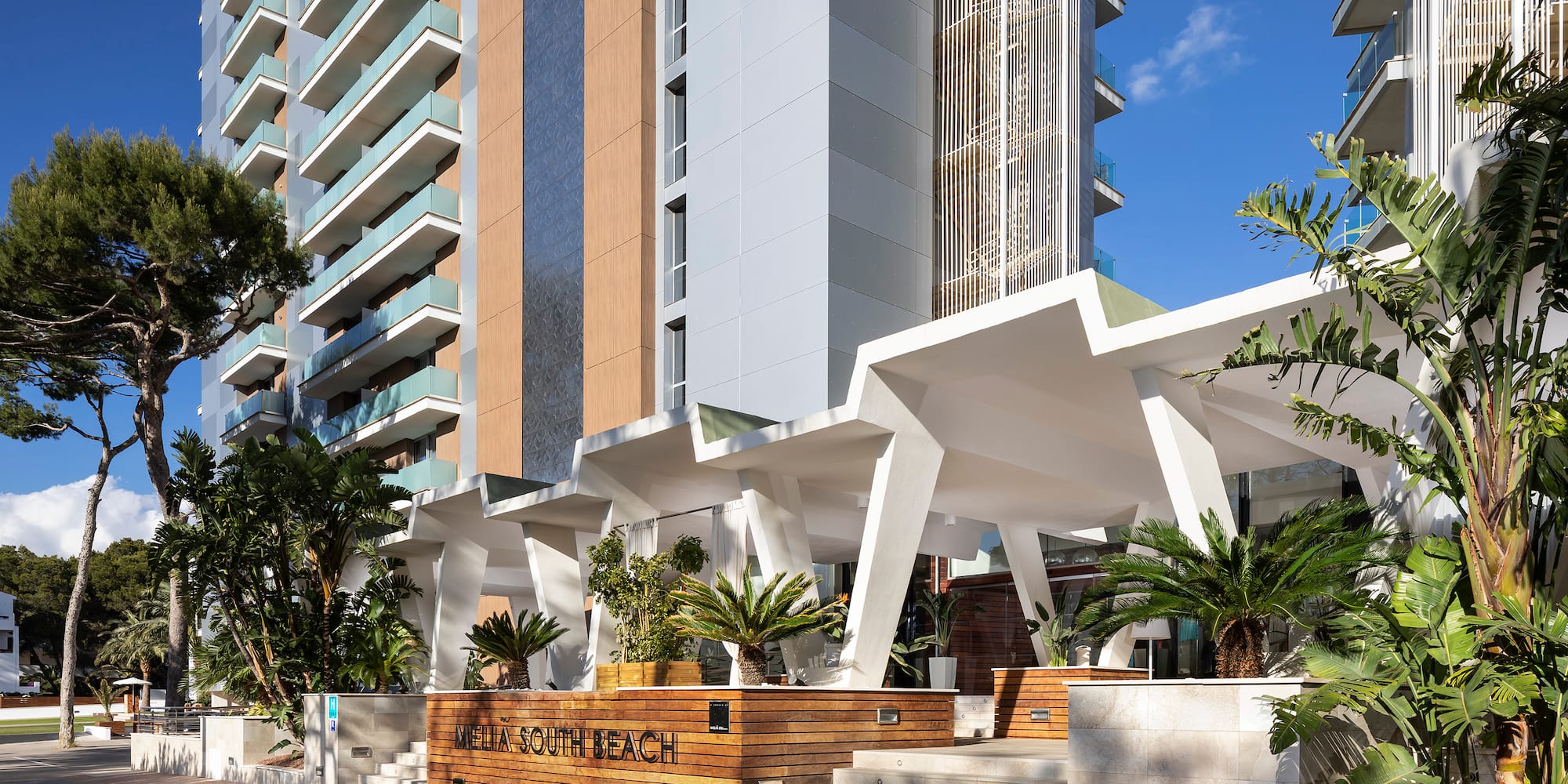 a building with palm trees and a walkway