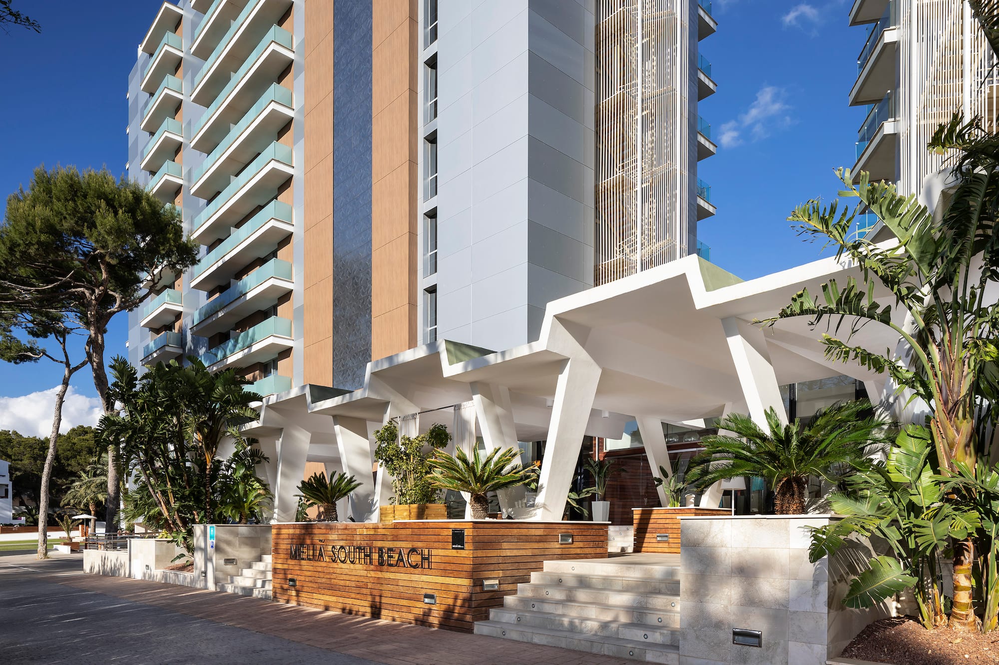 Meliá South Beach modern hotel exterior with geometric entrance, lush landscaping.