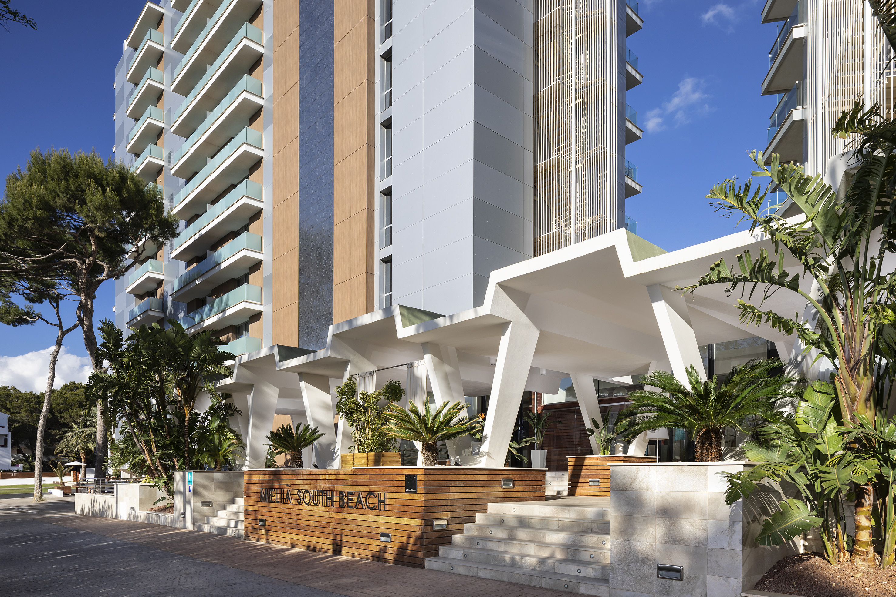 Meliá South Beach modern hotel exterior with geometric entrance, lush landscaping.