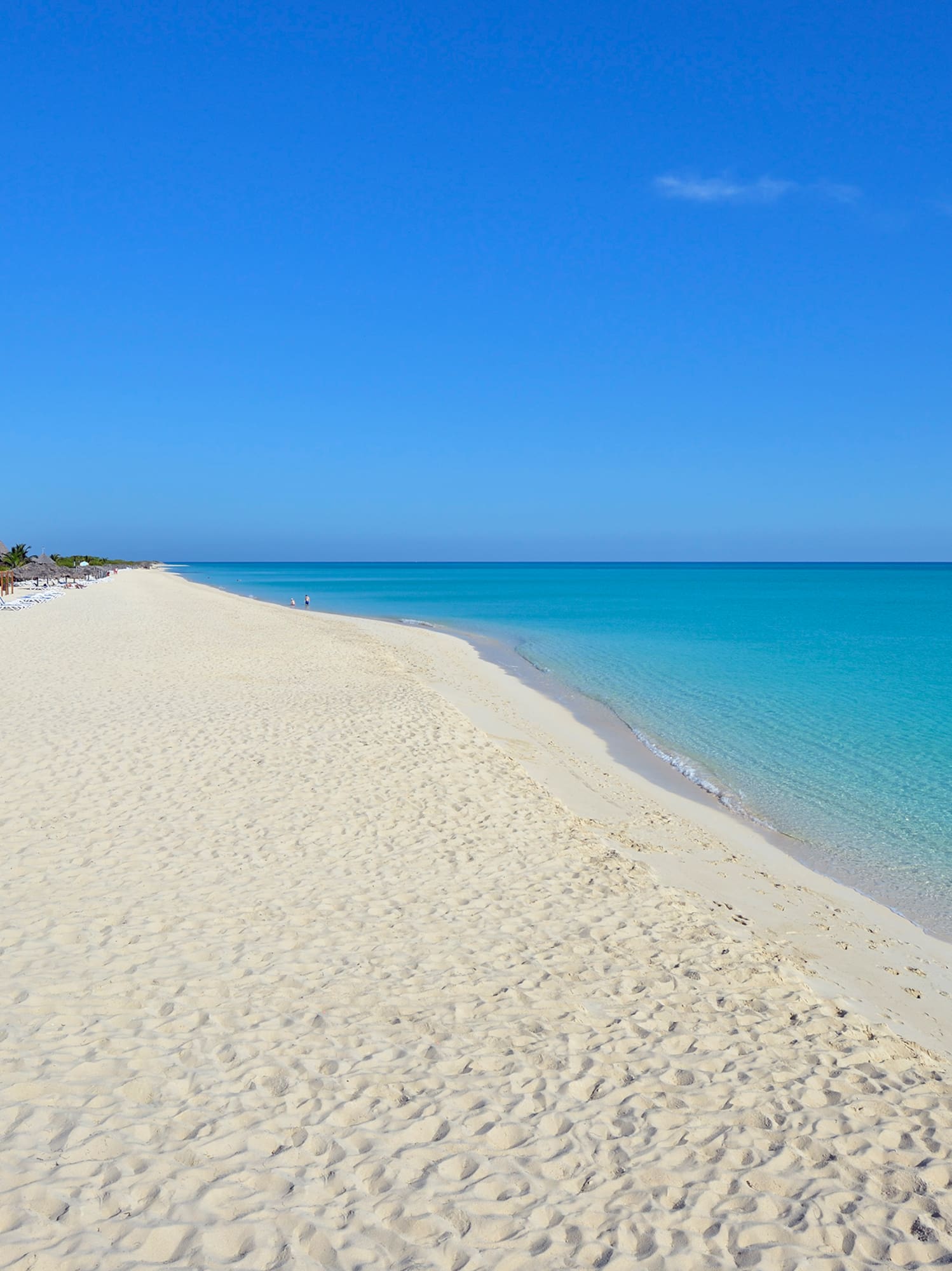 a beach with blue water and a clear sky