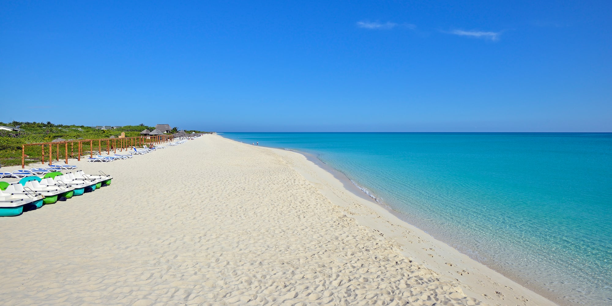 a beach with blue water and a clear sky