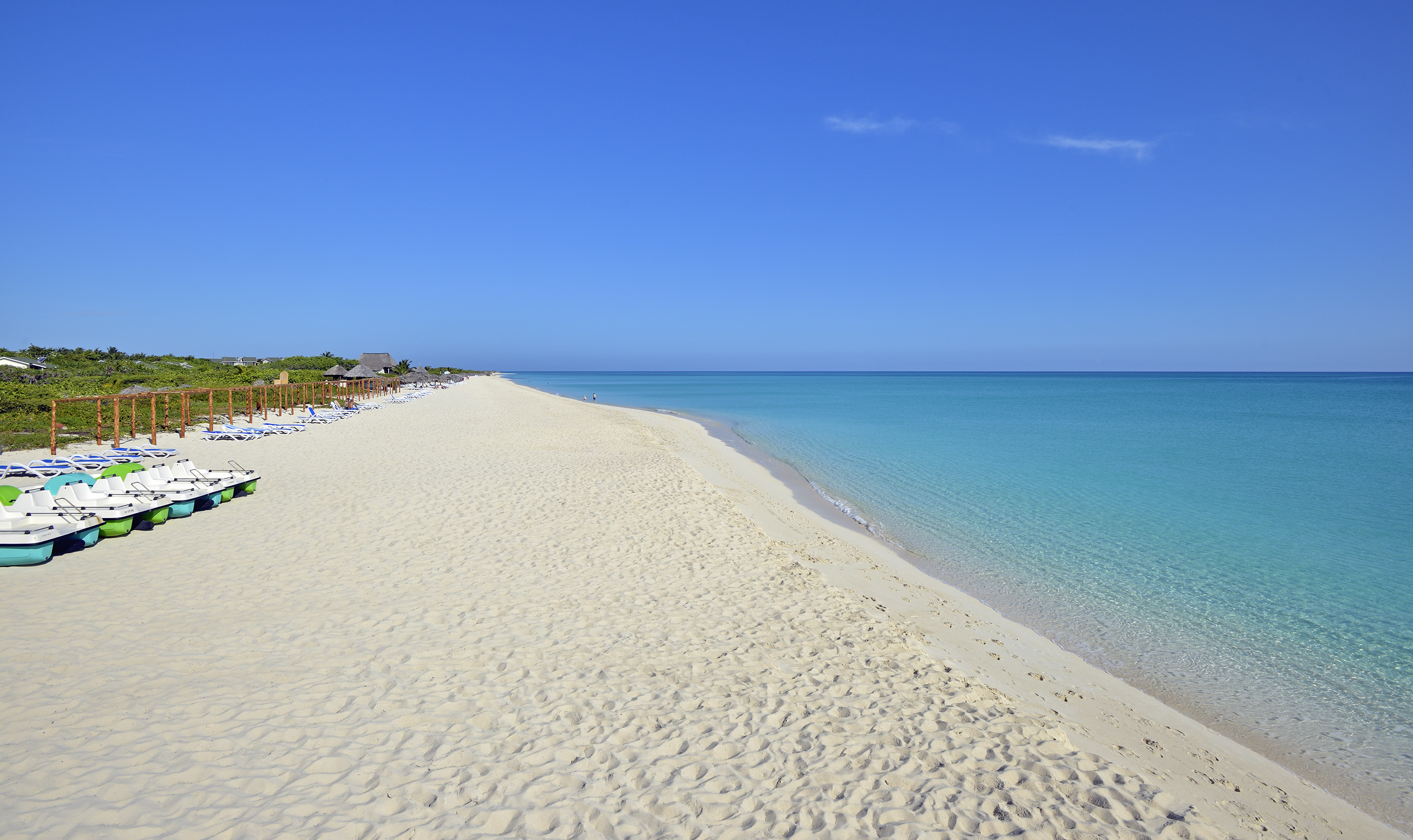 a beach with blue water and a clear sky