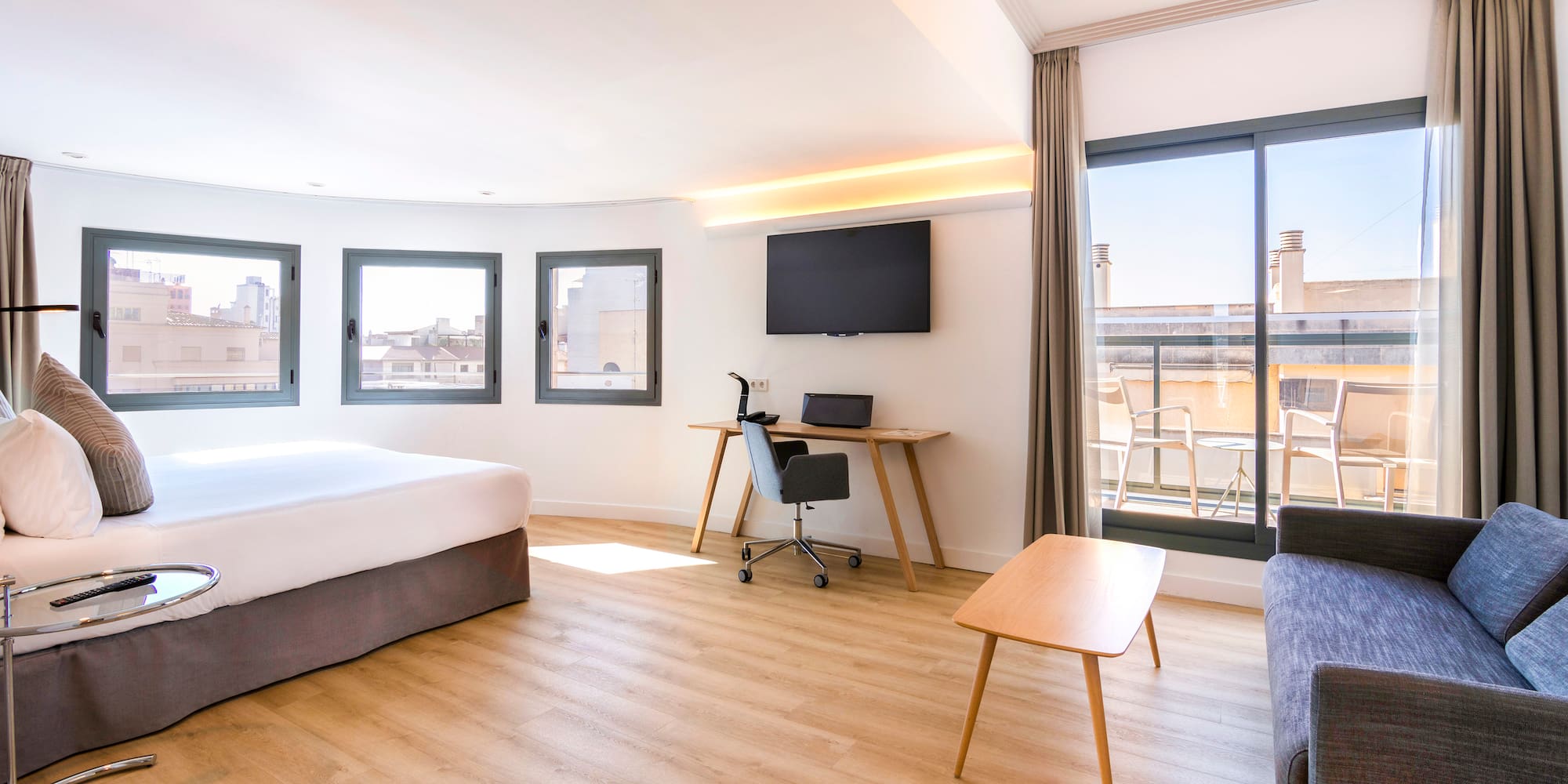 a room with a bed and a desk and a television