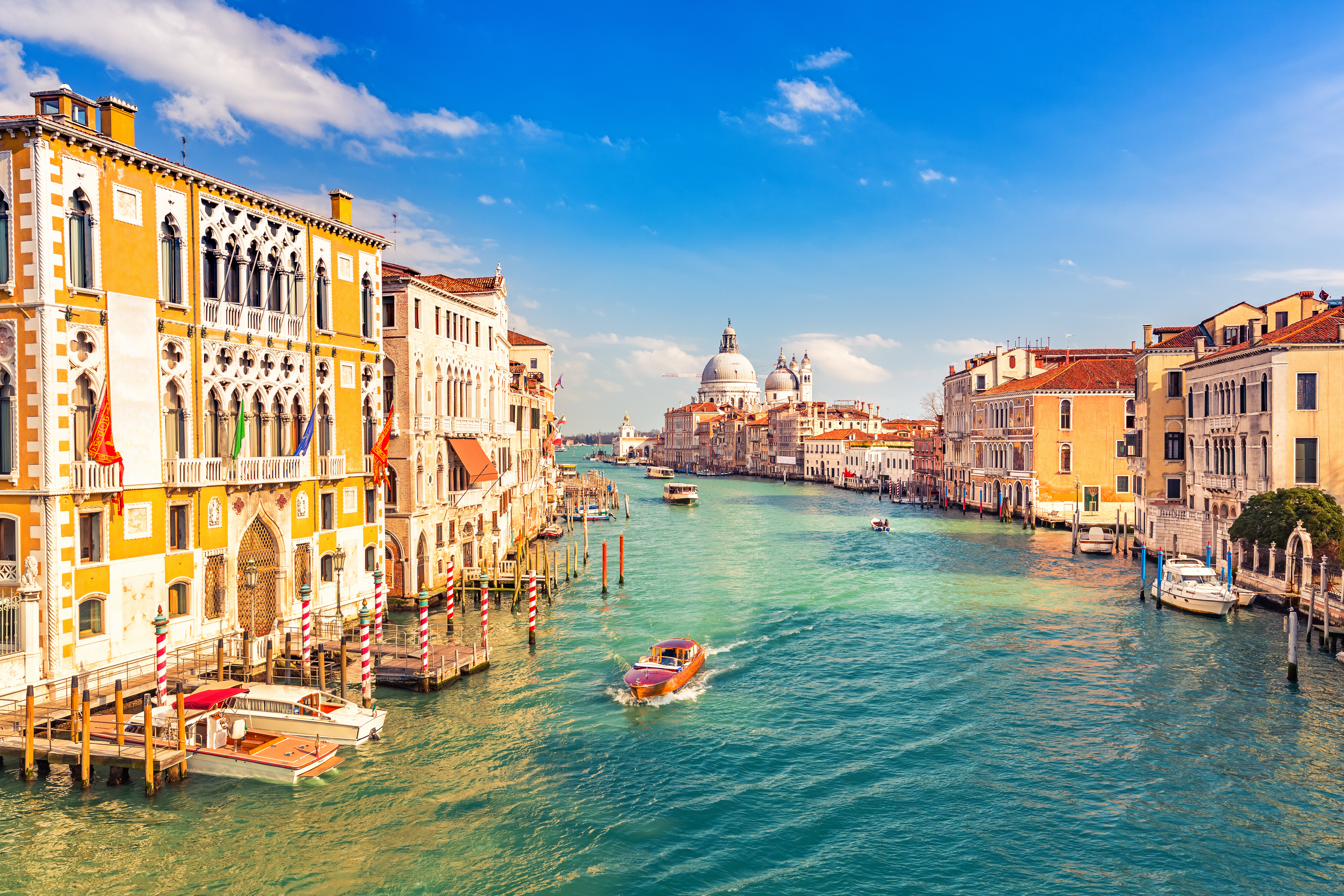 a water way with boats and buildings in the background with Grand Canal in the background