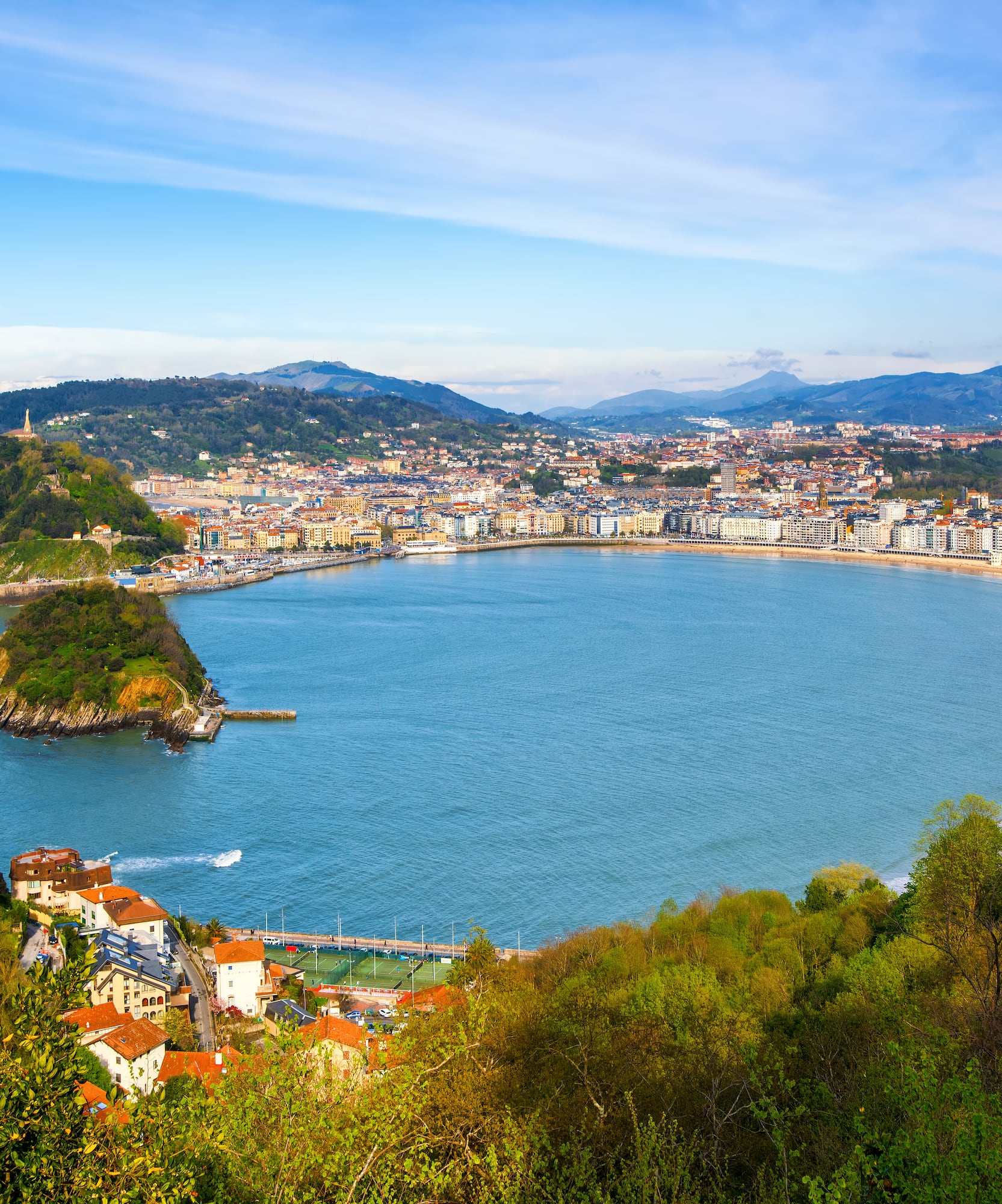 Scenic aerial view of San Sebastián, La Concha Bay, city, beach, and mountains.