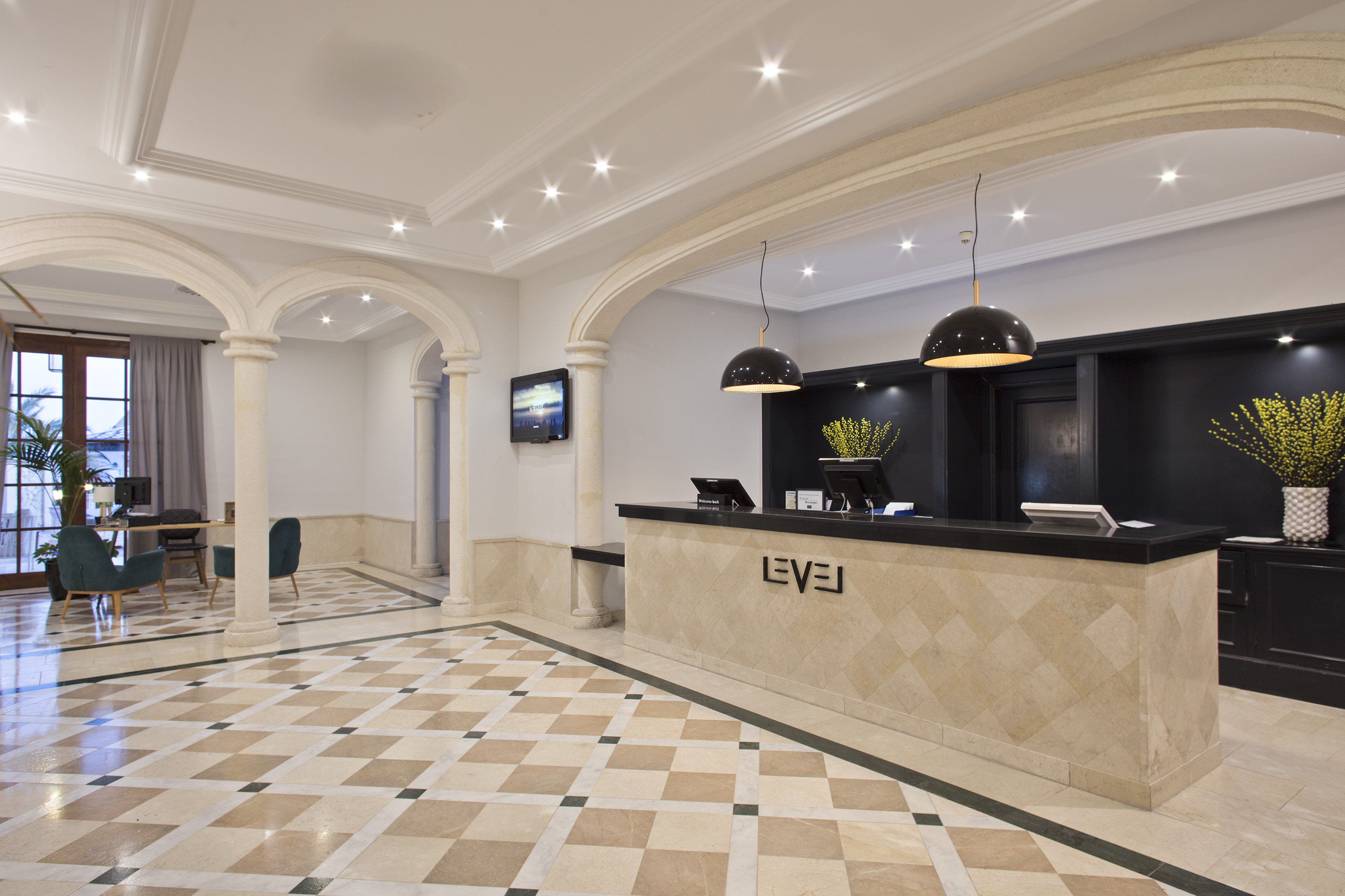 Modern luxury hotel reception with LEVEL desk, archways, and patterned marble floor.