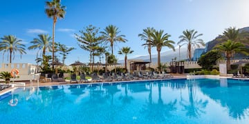 a pool with chairs and trees