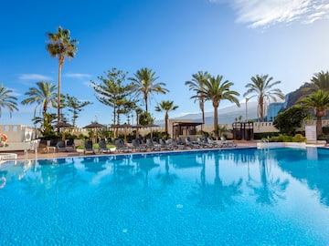 a pool with chairs and trees